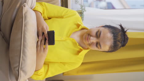 Vertical-video-of-Young-woman-texting-with-happy-expression.